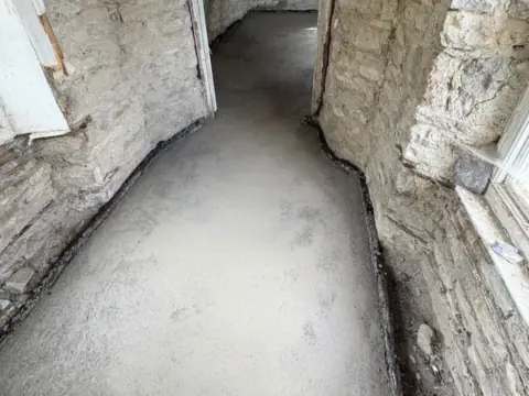 Lime screed down a stone-walled hallway, JAM Floor Screeding